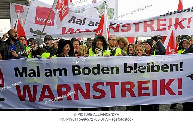 15 January 2019, Lower Saxony, Hannover: With a banner with the inscription ""Mal am Boden bleiben! Warning strike"" and flags of the Verdi service union...
