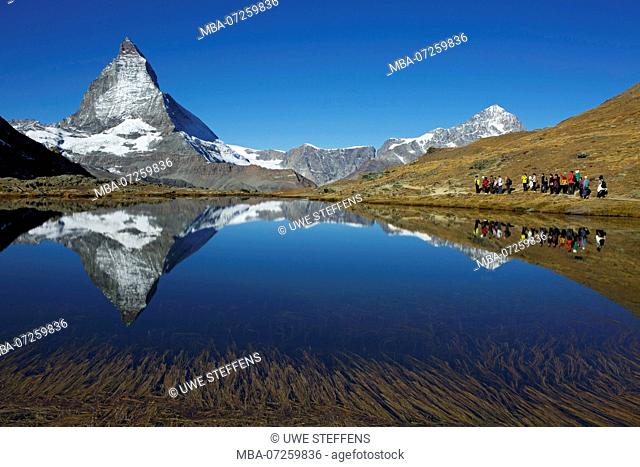 View over the upper Riffelsee near Zermatt to the Matterhorn. To the right is the Dent Blanche and a departing Chinese tourist group
