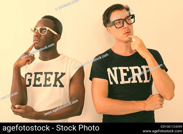 Studio shot of young African man with Scandinavian man as two nerds together against white background