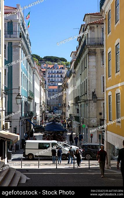 PRODUCTION - 05 April 2023, Portugal, Lissabon: Passers-by walk through the street ""Rua da Vitoria"" in Lisbon's old town. Photo: Viola Lopes/dpa