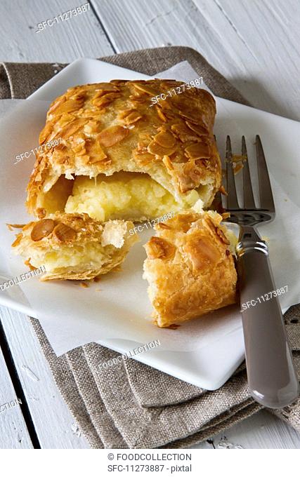 An apple turnover with a bite taken out of it on a plate with a cake fork