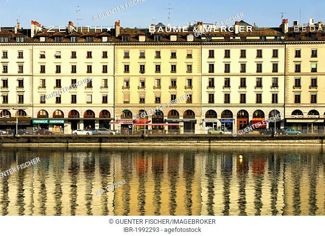 A row of houses on Quai des Bergues street is being reflected in the water of the Rhone River in downtown Geneva, Switzerland, Europe
