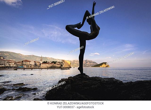 Statue of Ballerina on a rock in Budva city on the Adriatic Sea coast in Montenegro. Old Town and Sveti Nikola Island on background