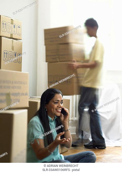 Woman on phone and unpacking boxes