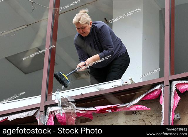 RUSSIA, DONETSK - DECEMBER 3, 2023: A woman clears broken glass from the floor of a beauty parlour damaged in a shelling attack by the Ukrainian Armed Forces