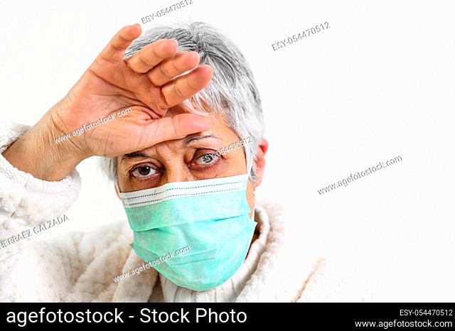 Covid-19. Sick senior woman portrait, wearing face protection mask, fever and coughing, pneumonia disease, risk patient, flu and cold