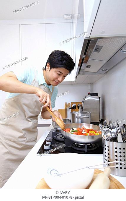 Man Cooking Food In Kitchen