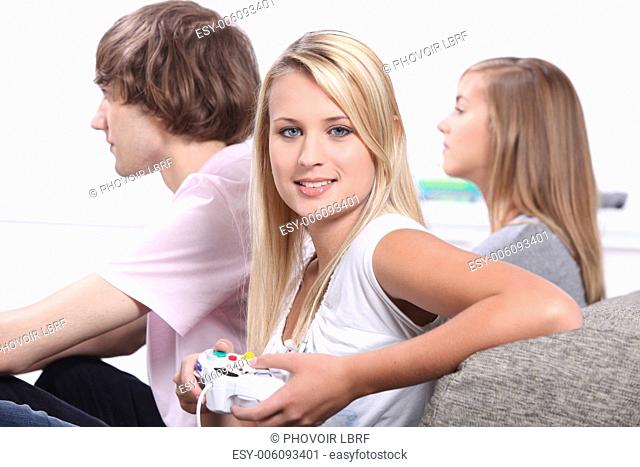 Three teenagers playing video games