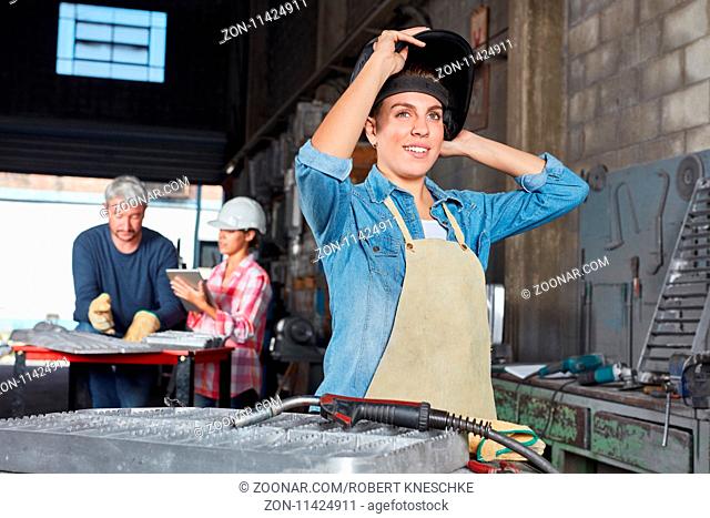 Junge Frau als Lehrling und Metallarbeiter in einem Handwerker Betrieb