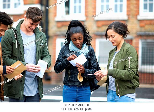 Young adult college students reading exam results on campus
