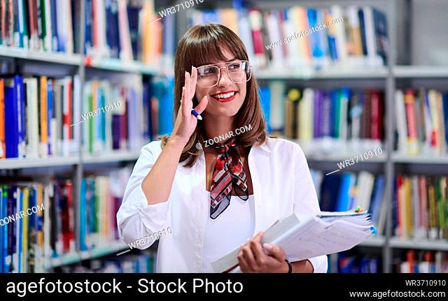 Young attractive woman wearing glasses and using school library