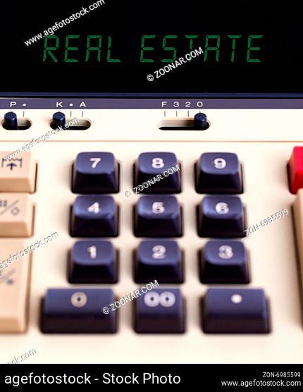 Old calculator showing a text on display - real estate