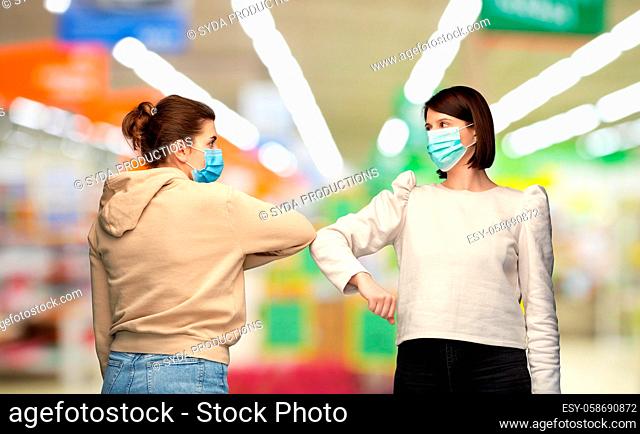 women in masks making elbow bump greeting gesture