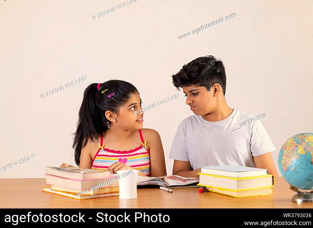 Portrait of happy girl and boy studying together