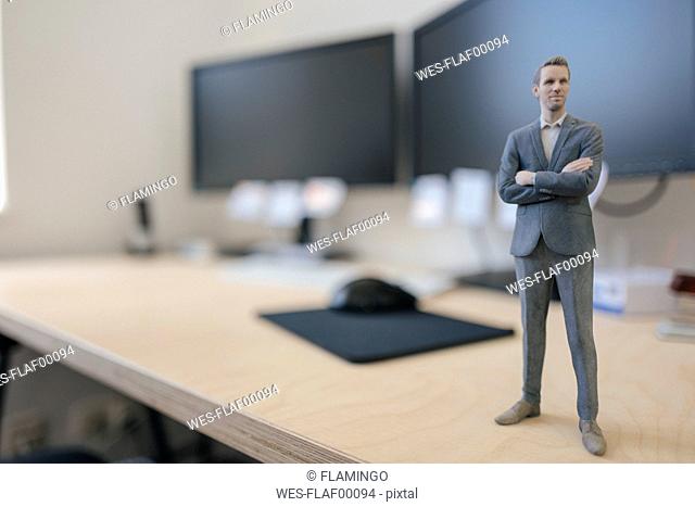Businessman figurine standing on desk in modern office