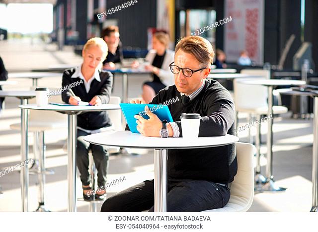 Lot of business people sitting in cafe of modern office building