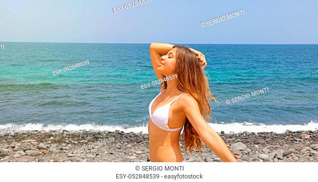 Happy beautiful sunshine girl. Portrait of pretty young woman enjoying summer outdoors. Sunny summer day under the hot sun on the Beach