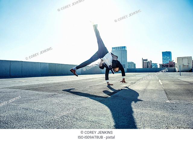 Businessman doing handstand on roof terrace, Los Angeles, California, USA