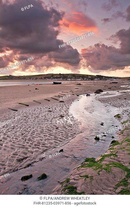 View of rainclouds gathering over sand banks of river estuary at sunrise, village of Instow on opposite bank, West Appledore, River Torridge, North Devon