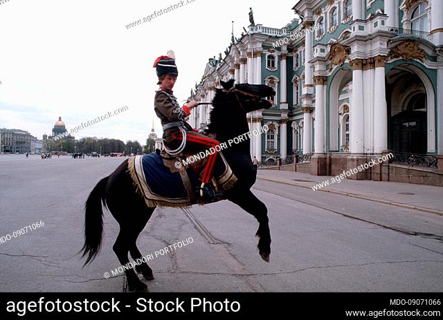 A boy disguised as a Cossack with a horse in front of the State Hermitage Museum. Leningrad today Saint Petersburg (Russia), May 14th, 1991