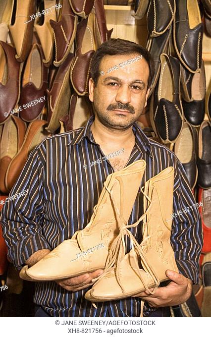 Bazaar, shoe maker holds boots he made for Brad Pitt to use in the film 'Troy', Antep. Gaziantep province, Anatolia, Turkey
