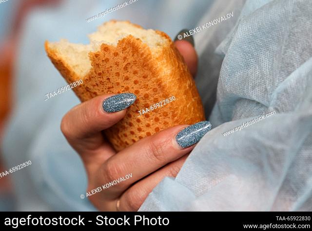 RUSSIA, ZAPOROZHYE REGION - DECEMBER 19, 2023: A woman holds a loaf of bread at the Berdyansk Bakery in the city of Berdyansk