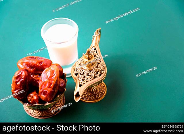 Ramadan, Dates in golden bowl, Milk, arabian Aladdin golden lamp vintage style on black green background