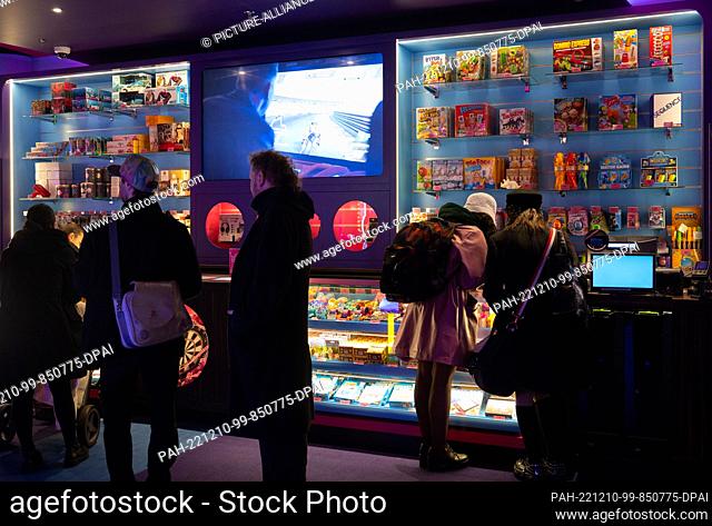 08 December 2022, Berlin: Visitors to the ""Gamestate"" arcade at Potsdamer Platz line up at a counter. A special kind of arcade - there you can play...