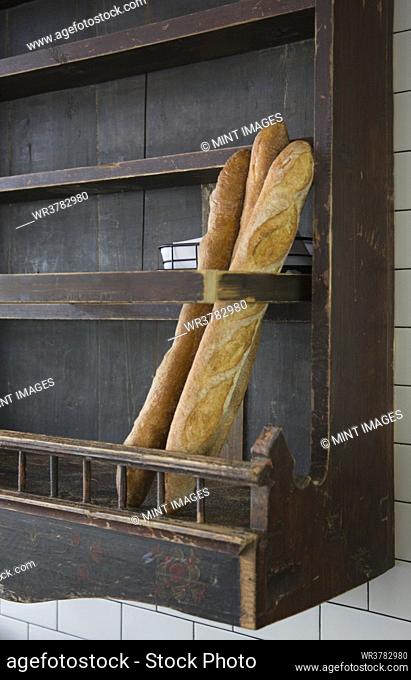 Baguettes in wooden wall rack at a restaurant