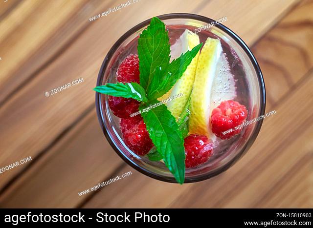 Summer Refreshing cocktail of natural fruits and various berries with ice and mint leaves infused with water. Contains lemon, raspberry, cherry, gooseberry