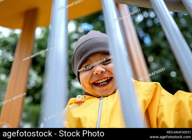 Happy cute boy looking through railing