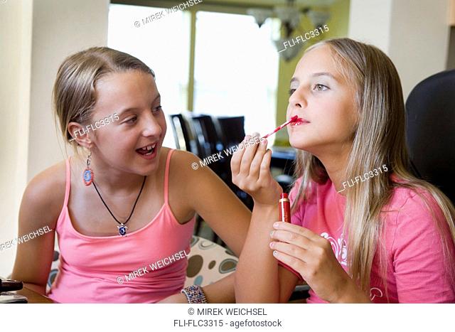 Two girls playing with make up at home