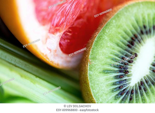 diet, food, healthy eating and objects concept - close up of ripe kiwi and grapefruit slices
