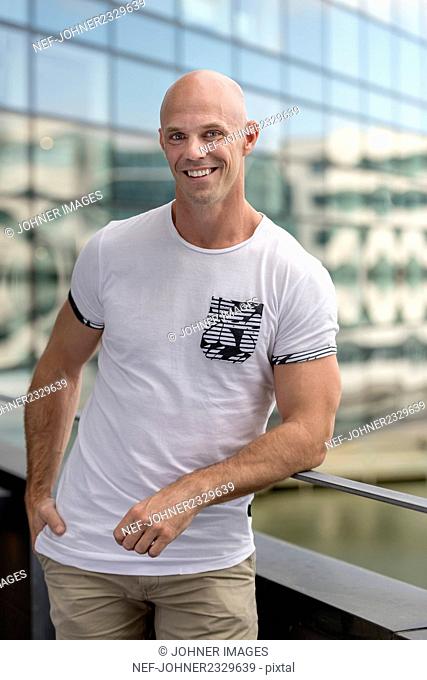 Smiling man standing on balcony