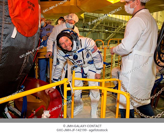 In the Integration Facility at the Baikonur Cosmodrome in Kazakhstan, Expedition 46-47 crewmember Tim Kopra of NASA (left) waits to board the Soyuz TMA-19M...