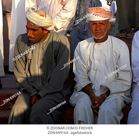 Zwei omanische Männer in der Nationaltracht Dishdasha und dem Mussar Turban auf dem Kopf, Nizwa, Sultanat Oman / Two Omani men in the national costume Dishdasha...