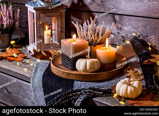 Autumn terrace or patio in night with pumpkins, lights and heather plant  (Calluna vulgaris)