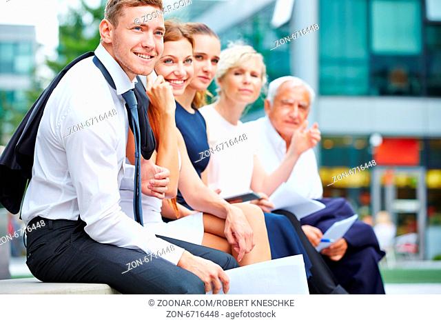 Erfolgreiches Business Team mit Männern und Frauen sitzt vor dem Büro