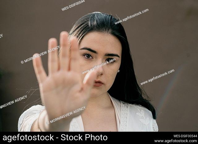 Young woman gesturing stop sign with hand