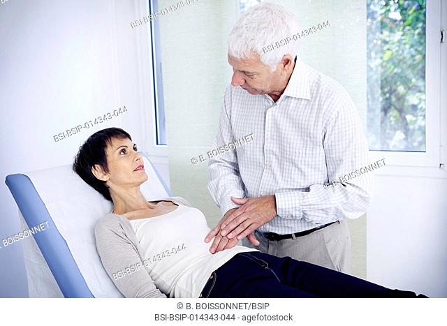 doctor examining patient's abdomen