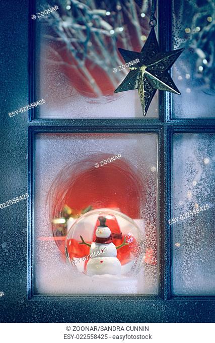 Frosted window with Christmas decoration inside at