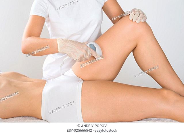 Close-up Of Young Woman Having Laser Treatment On Thigh At Beauty Clinic