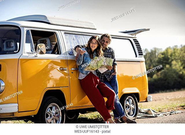 Couple on a road trip in their camper, looking at map
