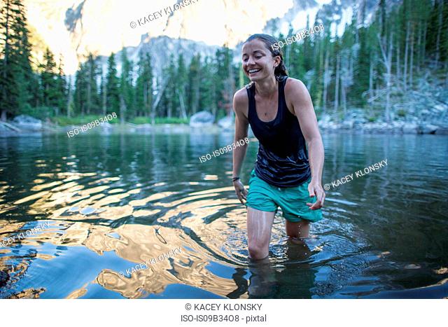 Young woman wading through lake, The Enchantments, Alpine Lakes Wilderness, Washington, USA