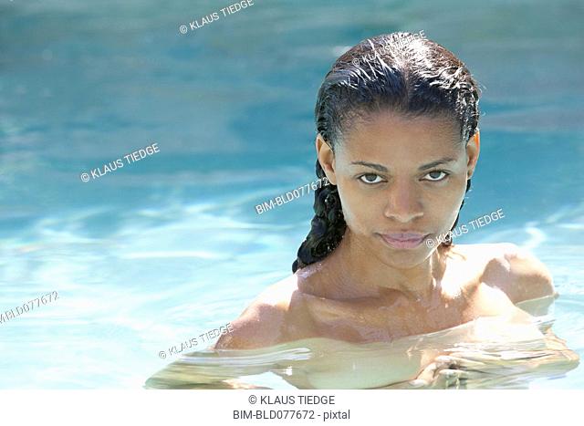 Nude mixed race woman in swimming pool