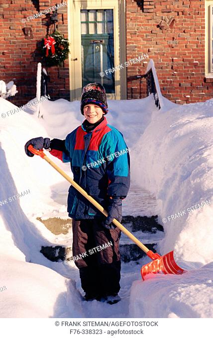 Boy shovelling snow