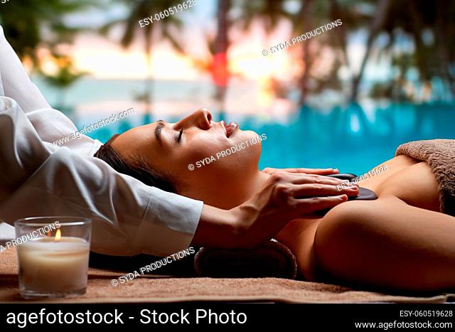 close up of woman having hot stone massage at spa