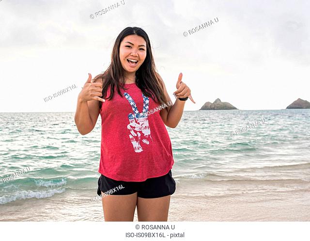 Woman giving thumbs up, Lanikai Beach, Oahu, Hawaii