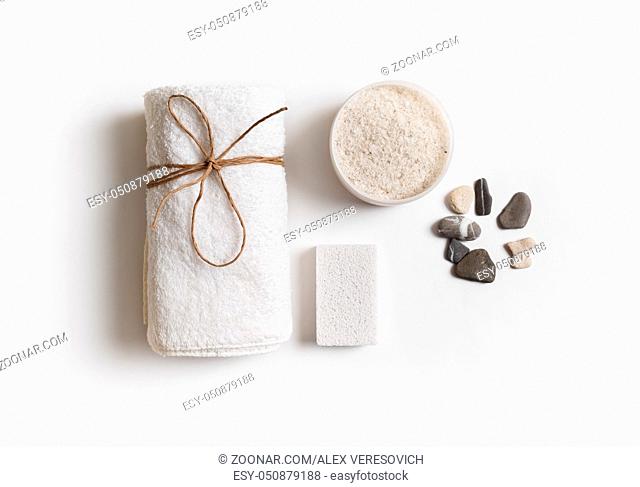 Beauty and spa concept. Towel, sea salt, pumice and stones on white paper background. Flat lay