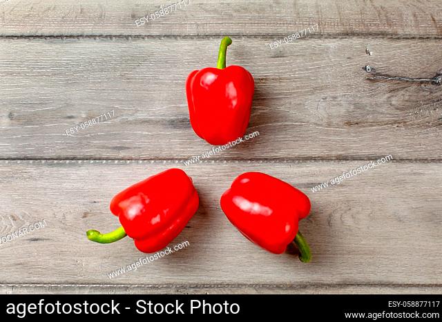 Table top photo - three bright red bell peppers arranged into 3 pointed star shape